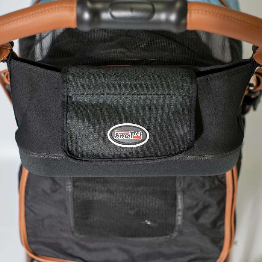 Black InnoPet® Dog Pram Organizer attached to stroller handlebar with multiple storage compartments