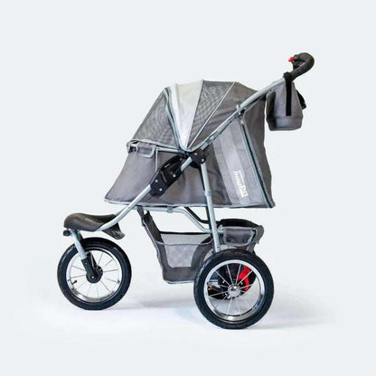 Innopet Comfort AIR ECO dog stroller in black and grey with mesh windows and air-filled tires on outdoor terrain