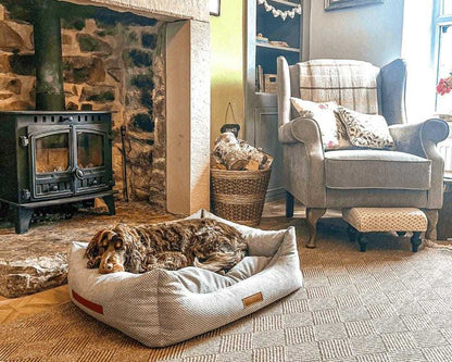 Orthopedic memory foam dog bed with beige knitted upholstery and supportive bolstered walls for joint comfort