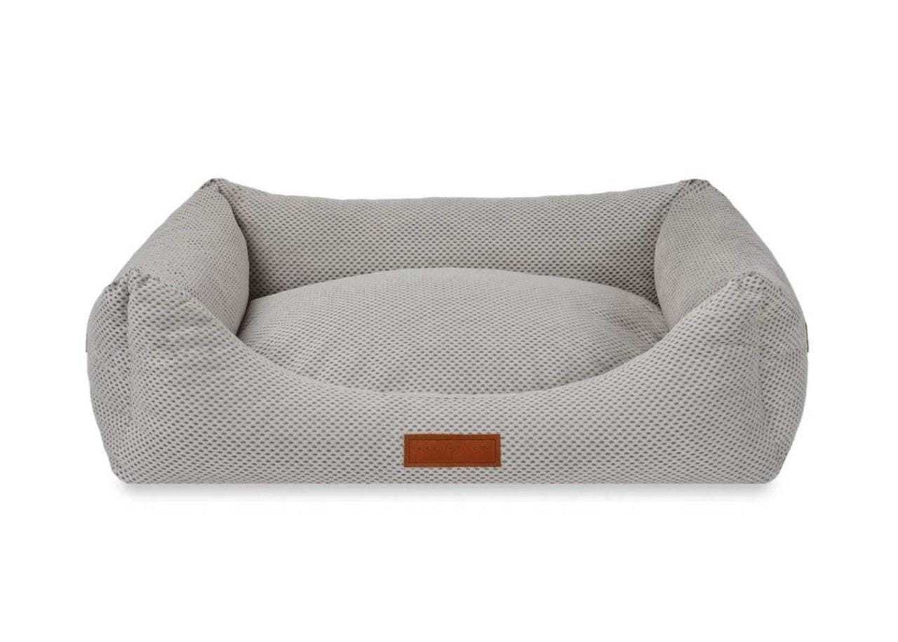 Orthopedic memory foam dog bed with beige knitted upholstery and nest-like bolster walls for joint support